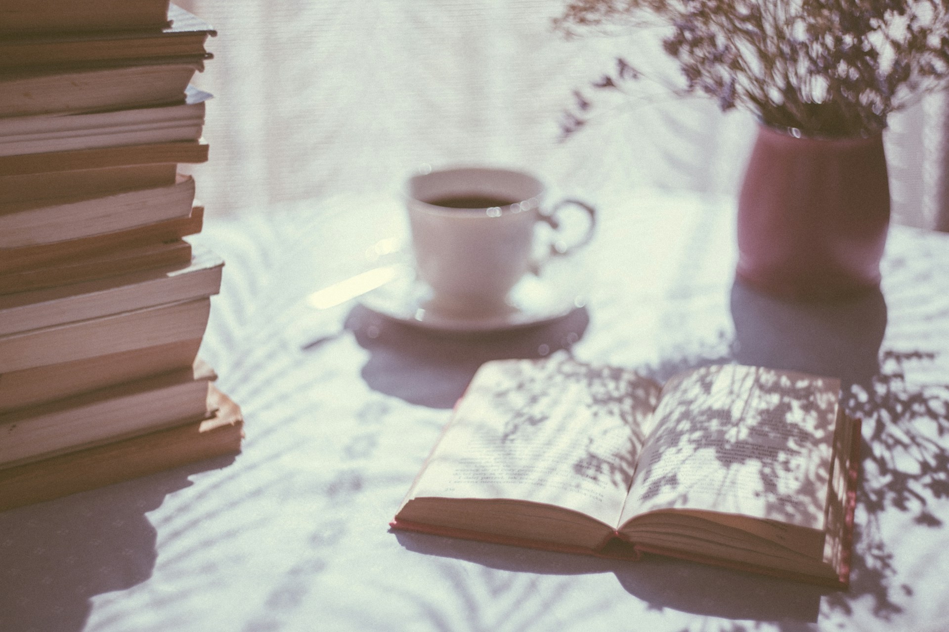 Coffee,  books and a vase on a reading table